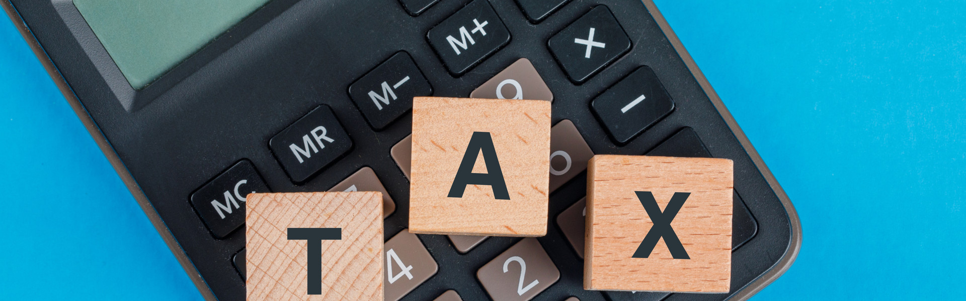tax-planning-concept-with-wooden-cubes-calculator-blue-table-flat-lay.jpg
